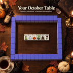 Halloween mahjong wall with purple backs on a candlelit table, six face-up tiles in the center