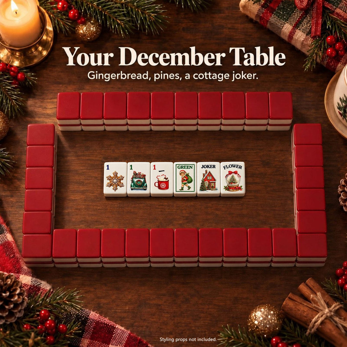 Christmas mahjong tiles inside a wall of deep red backed tiles on a festive table with candle, pinecones and plaid